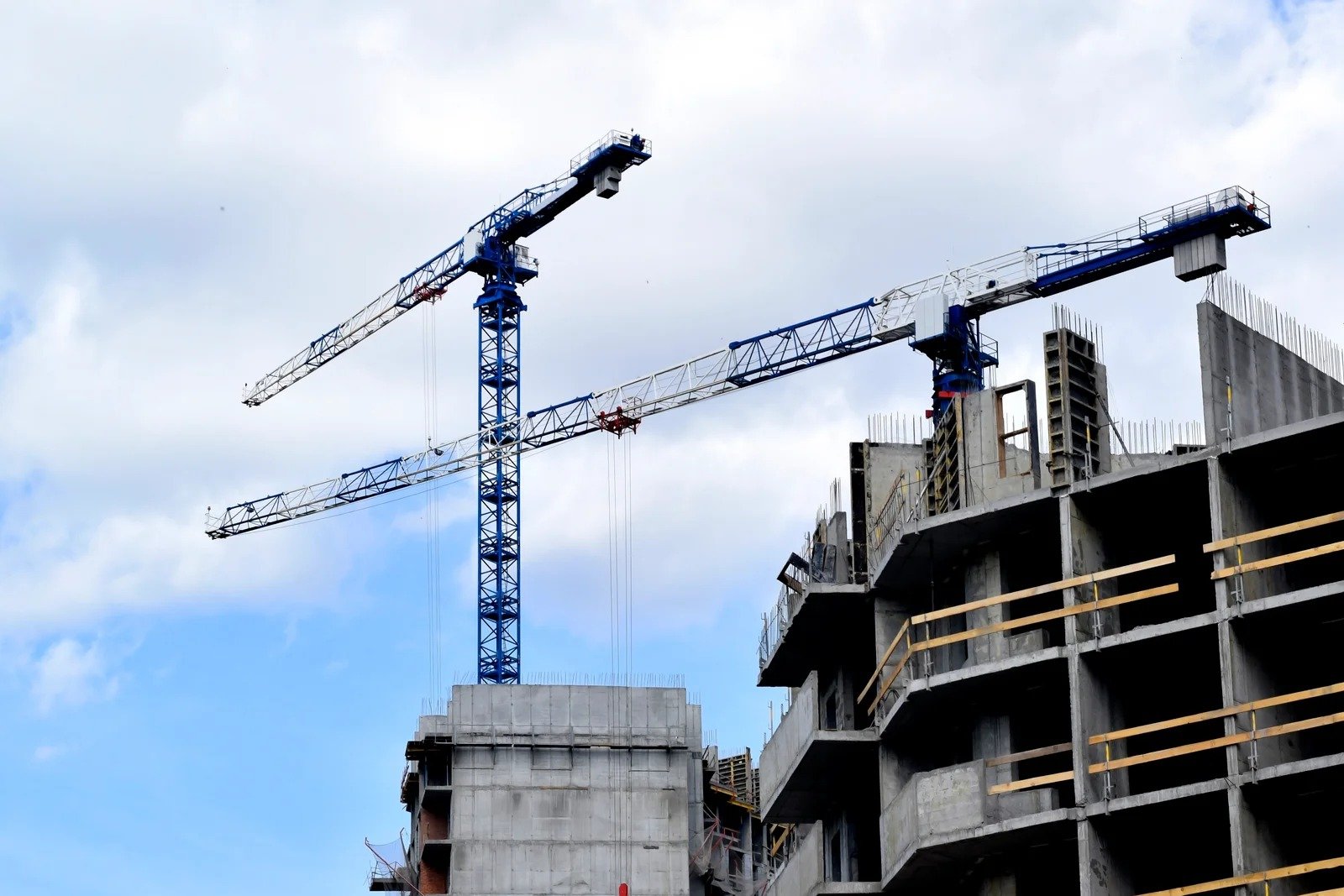 Larga fila de mamparas sanitarias de color beige/arena con diseño moderno, instaladas en un baño público de alto tráfico en un corporativo de Querétaro.