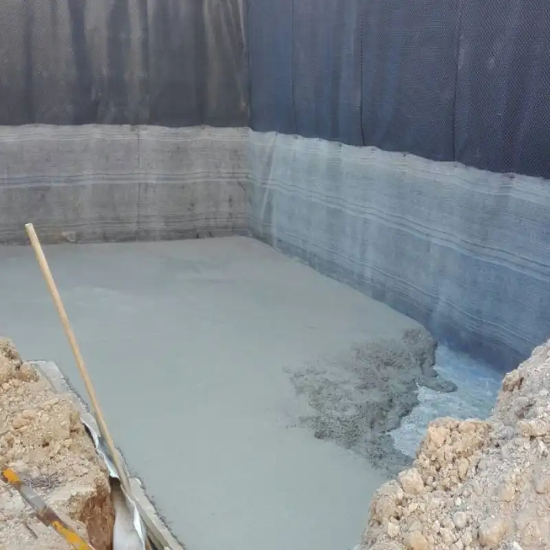 Foso de excavación para cimentación de un edificio en la CDMX. Se observa concreto fresco vertido y paredes protegidas con membranas impermeabilizantes para detener la humedad ascendente y asegurar la longevidad de la estructura.