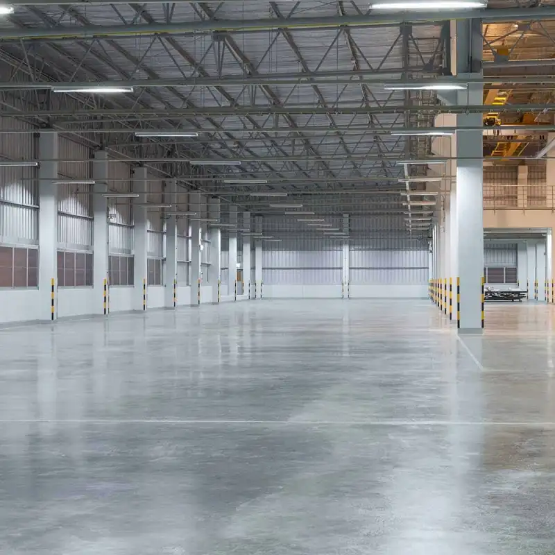 Vista interior de una nave industrial vacía con piso de concreto pulido. El techo y la cubierta metálica están listos tras la impermeabilización profesional con sistemas TPO en zonas industriales de Vallejo o Iztapalapa.