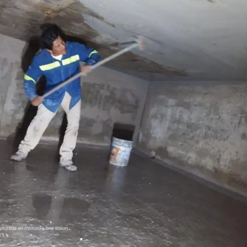 Técnico de Quantumef aplicando mortero cementoso contra la presión hidrostática dentro de una cisterna de 50,000 litros en un Centro Comercial de Santa Fe, CDMX. El recubrimiento garantiza la estanqueidad total y el suministro de agua.