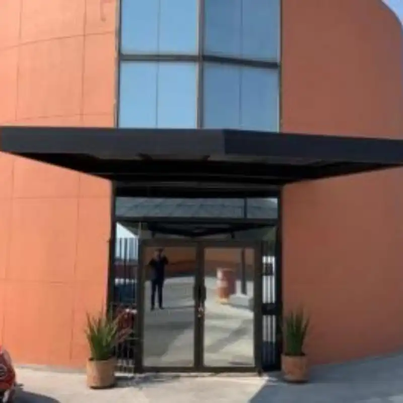 Entrada principal de un edificio corporativo con fachada de color salmón en Lomas Verdes, Naucalpan, Estado de México, mostrando el acabado final del proyecto de pintura exterior de Quantumef.