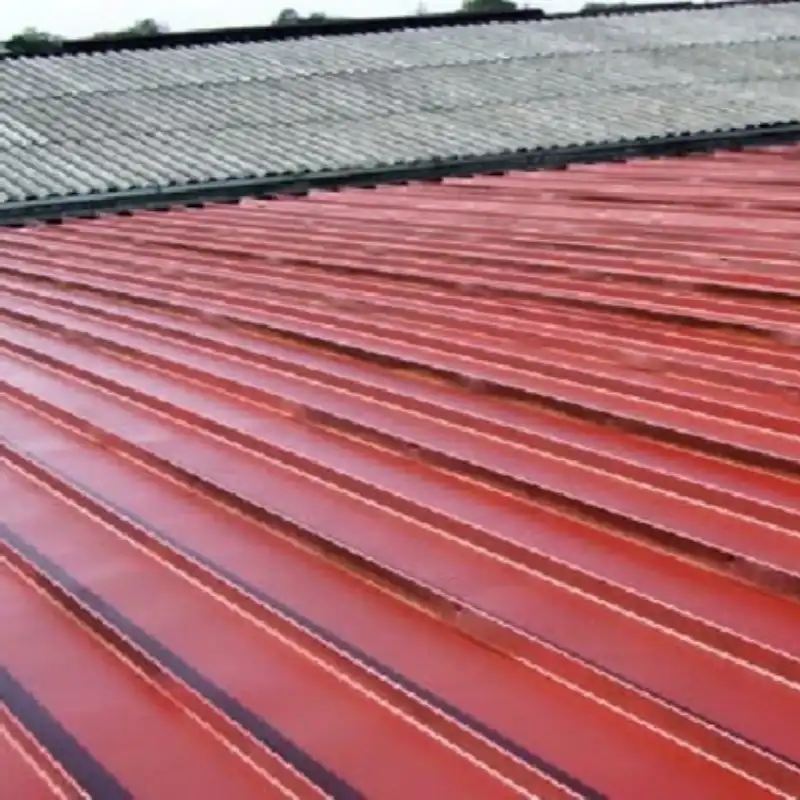 Vista superior de una cubierta metálica roja recién impermeabilizada con sistema TPO, contrastando con la cubierta antigua. El proyecto en Cuautitlán Izcalli aseguró la resistencia y eliminó goteras en la bodega logística, entregado en tiempo récord.