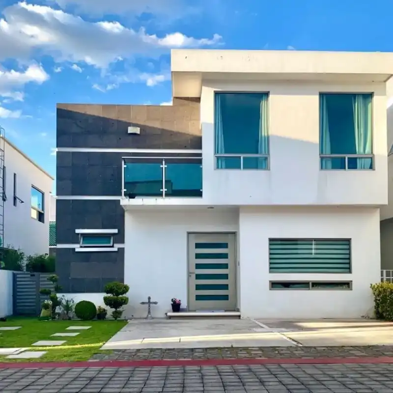 Fachada moderna y minimalista recién pintada de blanco en una residencia en Metepec o Interlomas, demostrando el embellecimiento y calidad de los acabados de Quantumef.